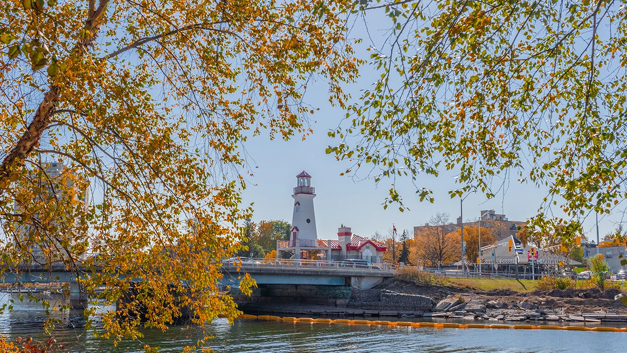 Port Credit lighthouse during the fall - October of 2022 with orange and yellow leaves.