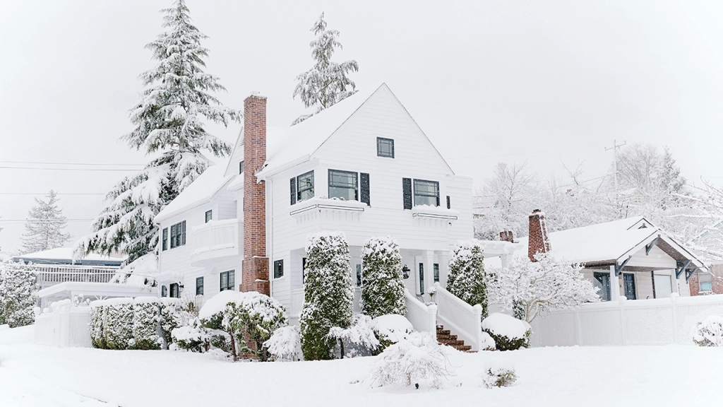 An image of the exterior of a home in January covered in snow.