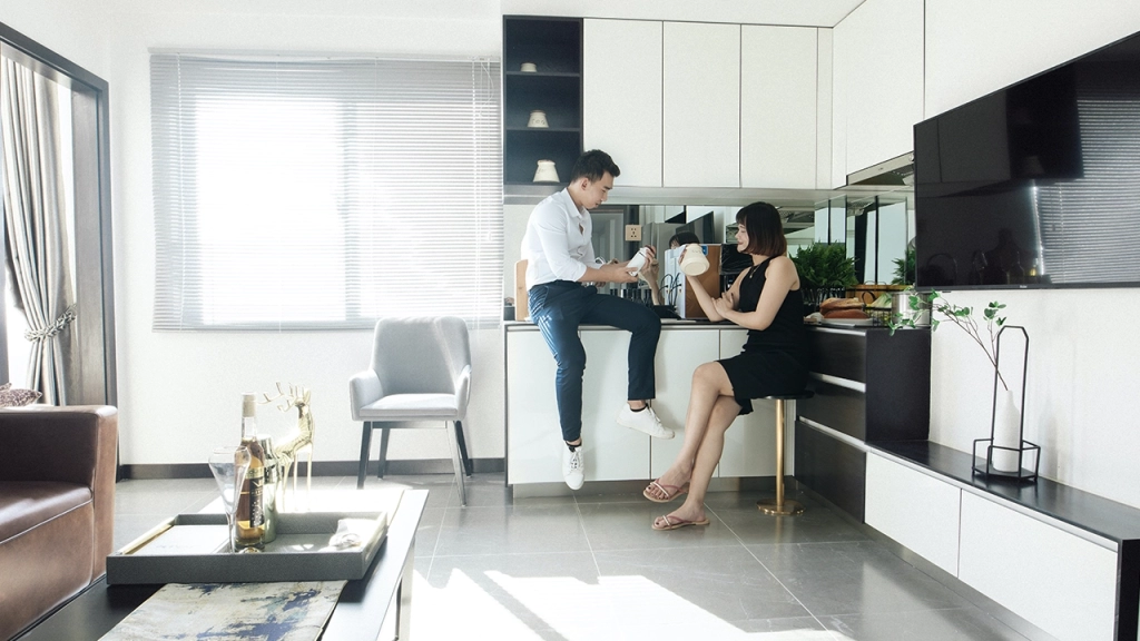An image of a couple sitting in the kitchen of their condo.