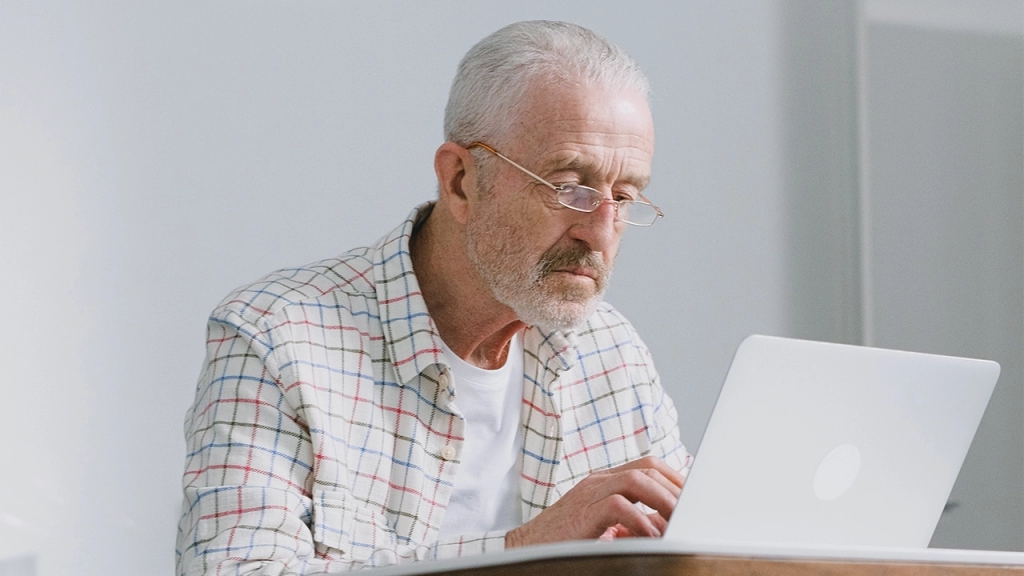An image of an Ontario landlord looking on his computer reviewing several tenant applications for their rental property.