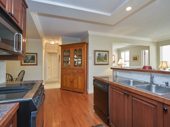 Kitchen facing towards living room + second bedroom of 162 Reynolds Street #203