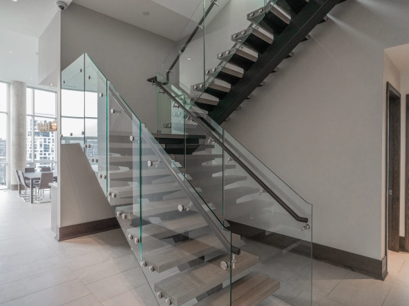 Interior image of 169 Fort York Blvd's upper penthouse showing the glass staircase that leads to the rooftop terrace.