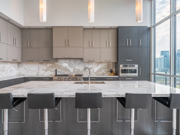 Interior image of 169 Fort York Blvd's upper penthouse showing kitchen island with the brown cabinetry in the back.