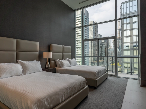 Interior image of 169 Fort York Blvd's upper penthouse showing one of the bedrooms facing east with the CN tower in sight.