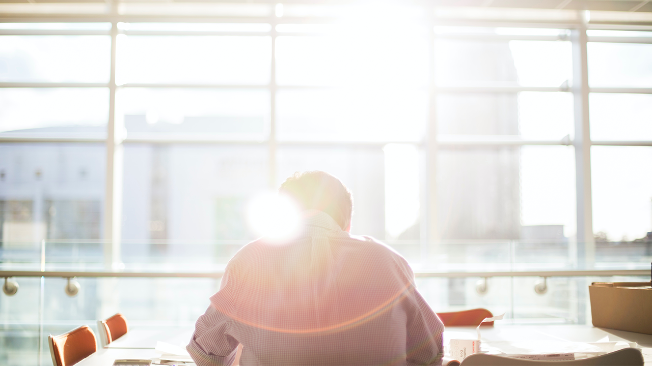 An image of a real estate lawyer taken from behind reviewing a status certificate document.