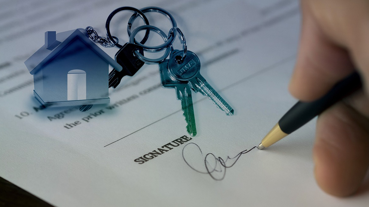 An image of someone signing a real estate contract to sell their home.