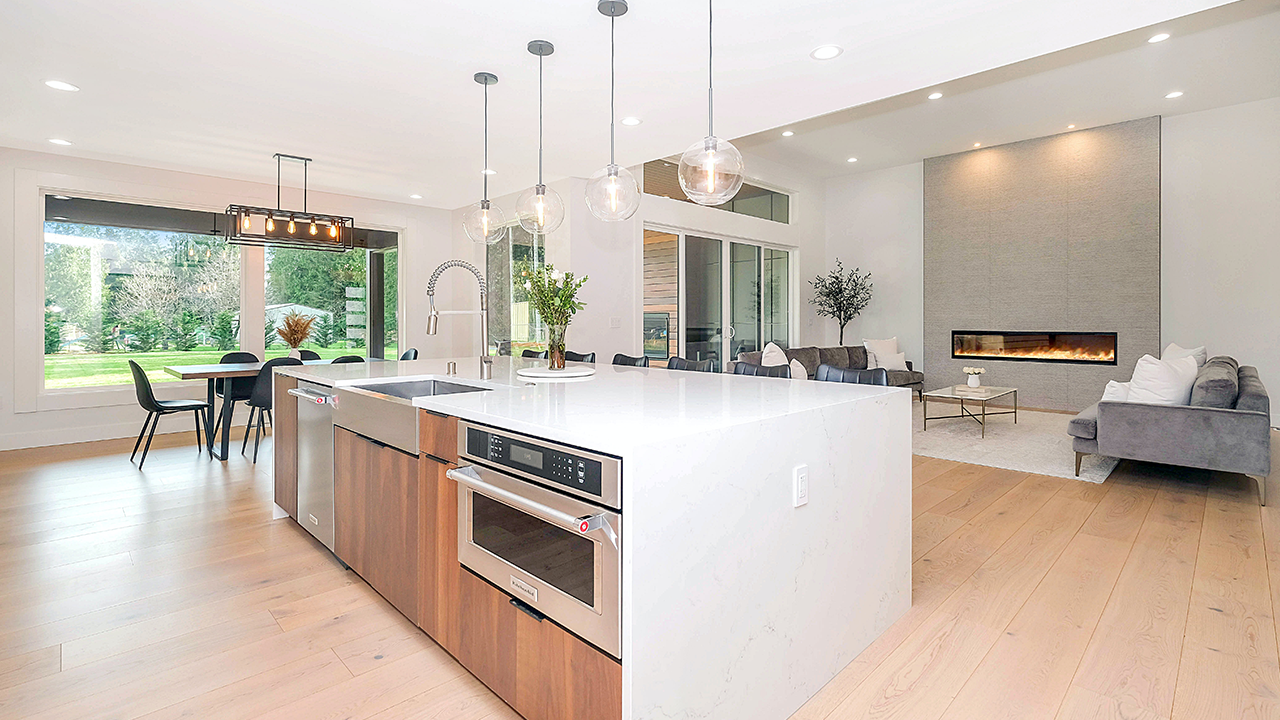 An interior image of a luxury home's kitchen with white, granite counter-tops.