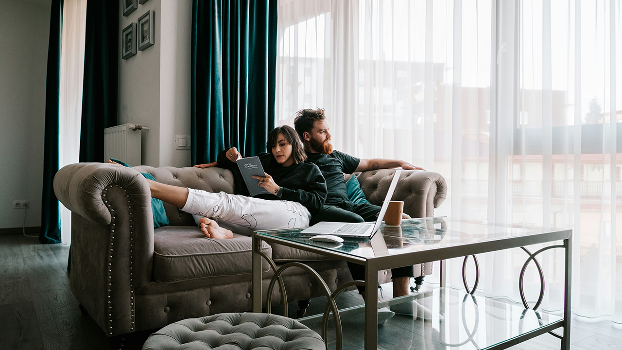 An image of a young professional couple sitting on a couch in their Toronto condo.
