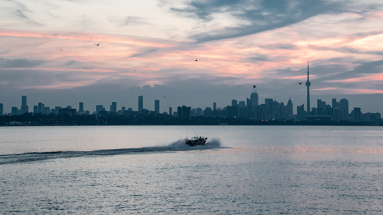 An image of a boat on Lake Ontario with the Etobicoke and Toronto skyline in the background.