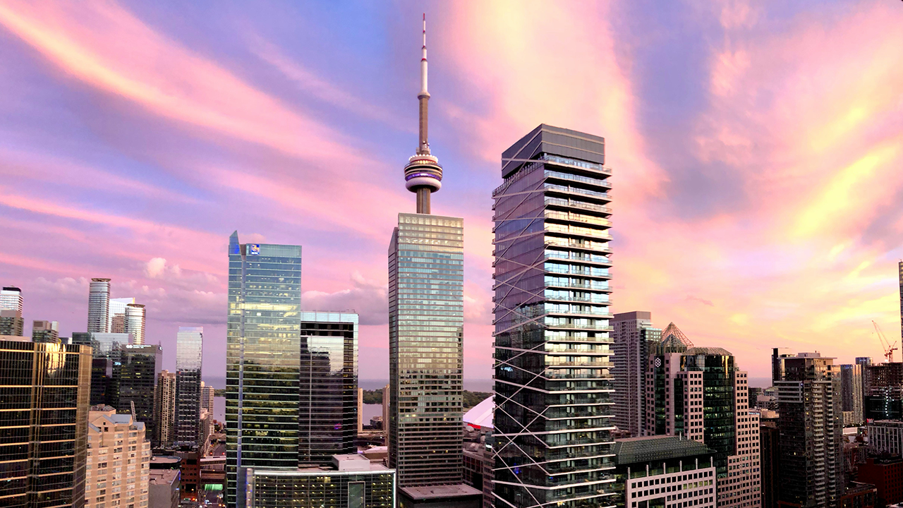 Investing in Toronto Real Estate - an image of the CN Tower taken during a beautiful sunset.
