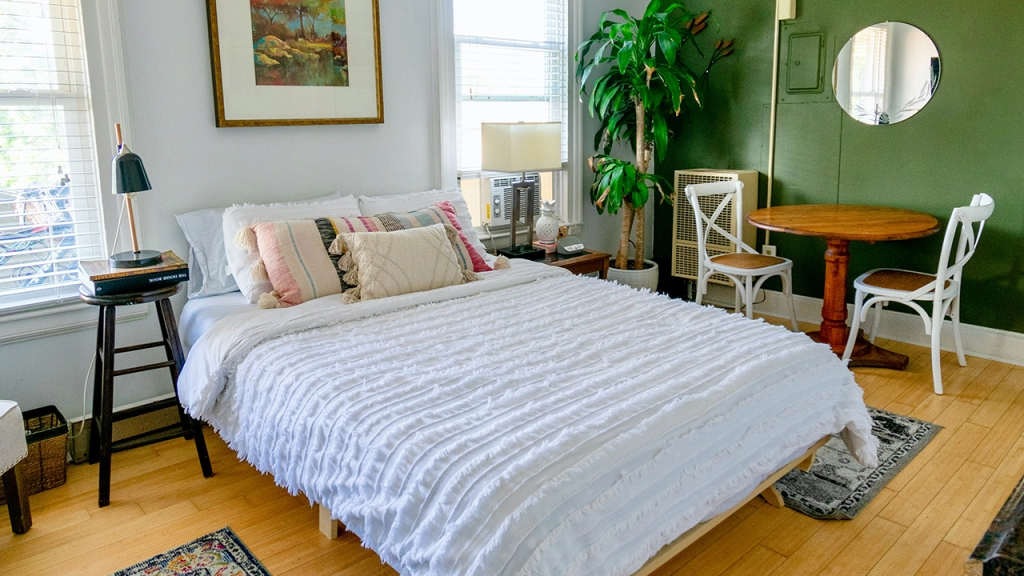 An image of a bed in a studio apartment. What is a studio apartment?