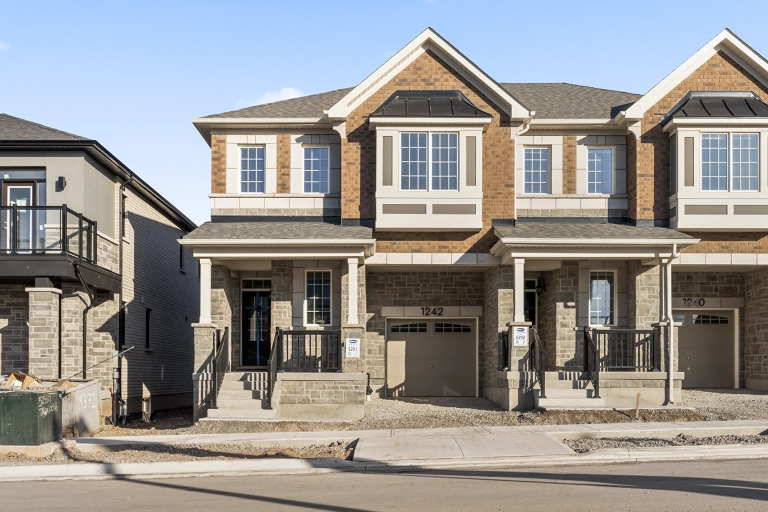 Exterior and outside image of 1242 Wheat Boom Drive located in Oakville, Ontario, Canada. The end-unit townhome is currently advertised for rent.