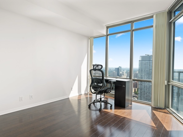 Living room with desk overlooking Toronto at 832 Bay Street unit 4807 located in Toronto, Ontario, Canada.