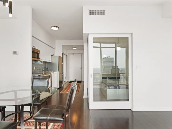 Living room looking towards the bedroom with doors closed at 832 Bay Street unit 4807 located in Toronto, Ontario, Canada.