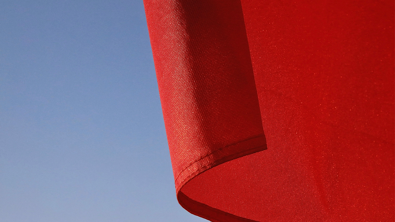 An image of a red flag against a blue sky background.